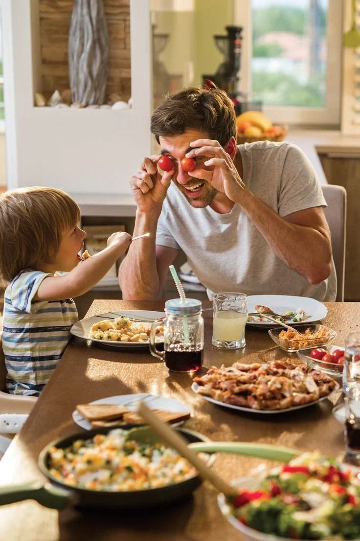 Father’s Day celebration with a father and child sharing food and laughter around the dinner table.